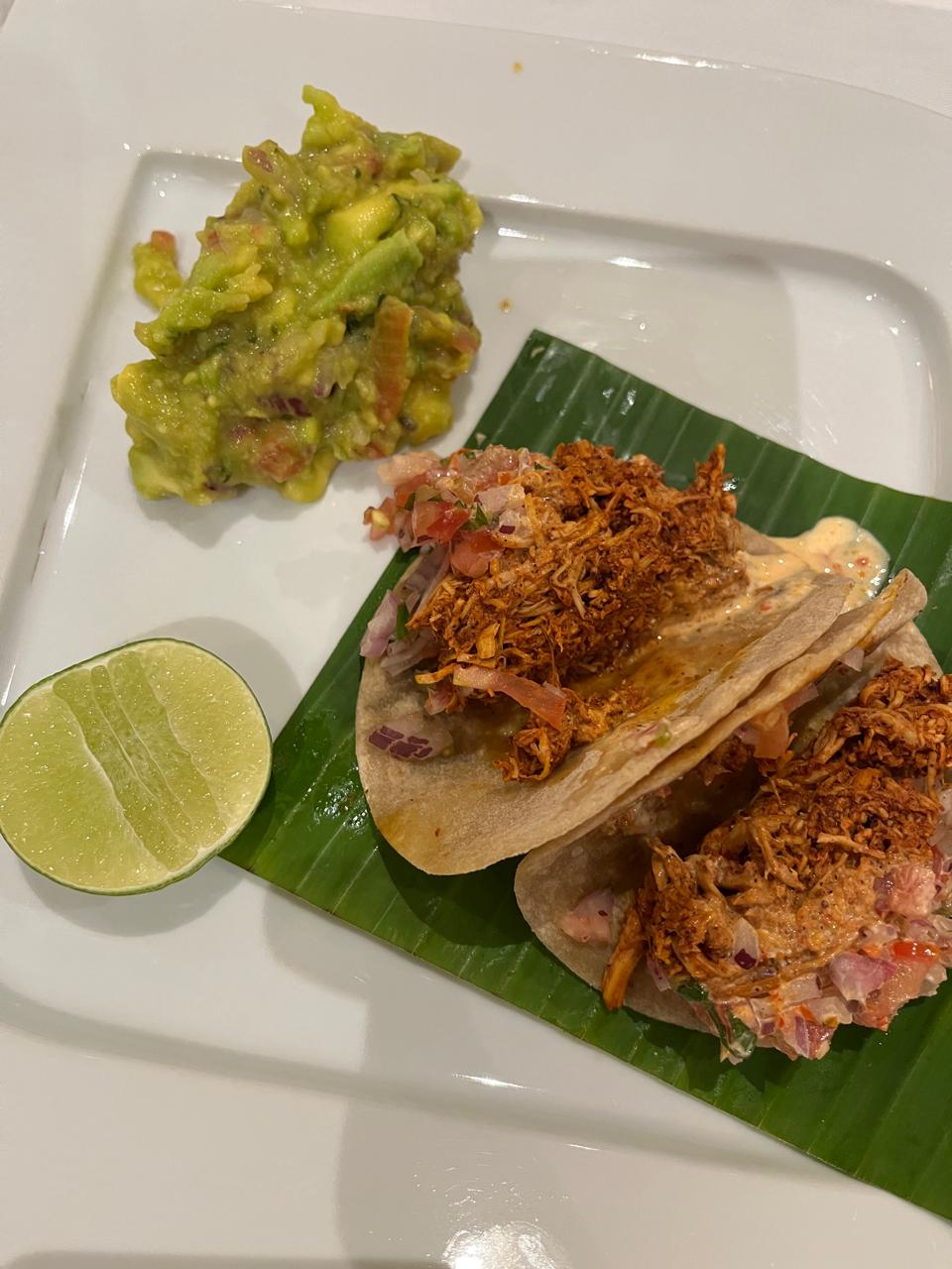 Tacos served with lime and salsa on a wooden board